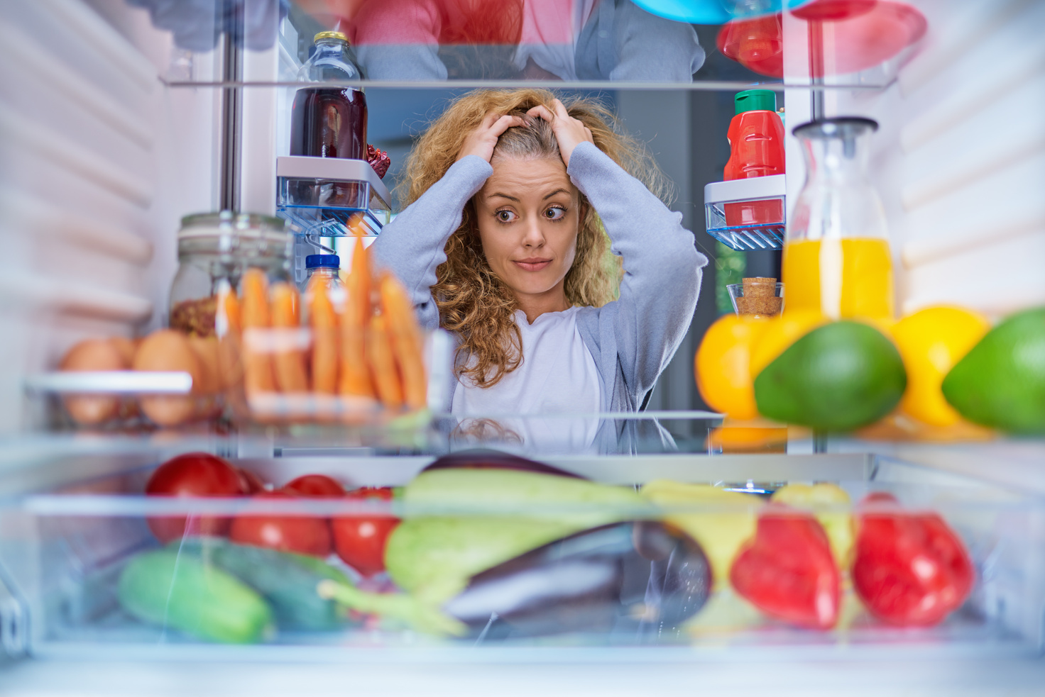 Woman in front of fridge.